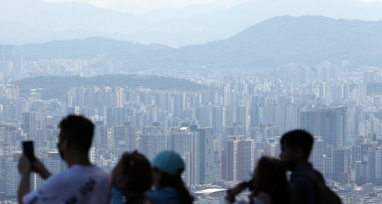 시민들이 서울 남산에서 도심 아파트 밀집 지역을 내려다보고 있다. <연합뉴스>